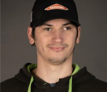 a man in front of a green SERVPRO truck