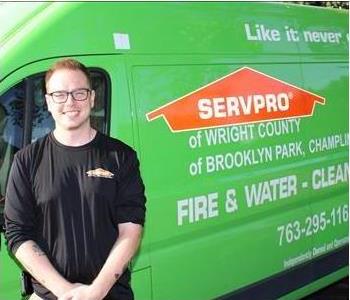 a man in front of a green SERVPRO truck